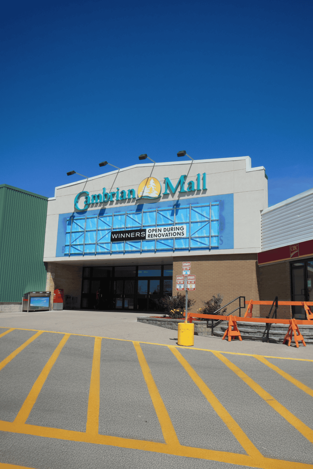 1. Large shopping mall with signage for Cambrian Mall, open during renovations, under bright blue sky.