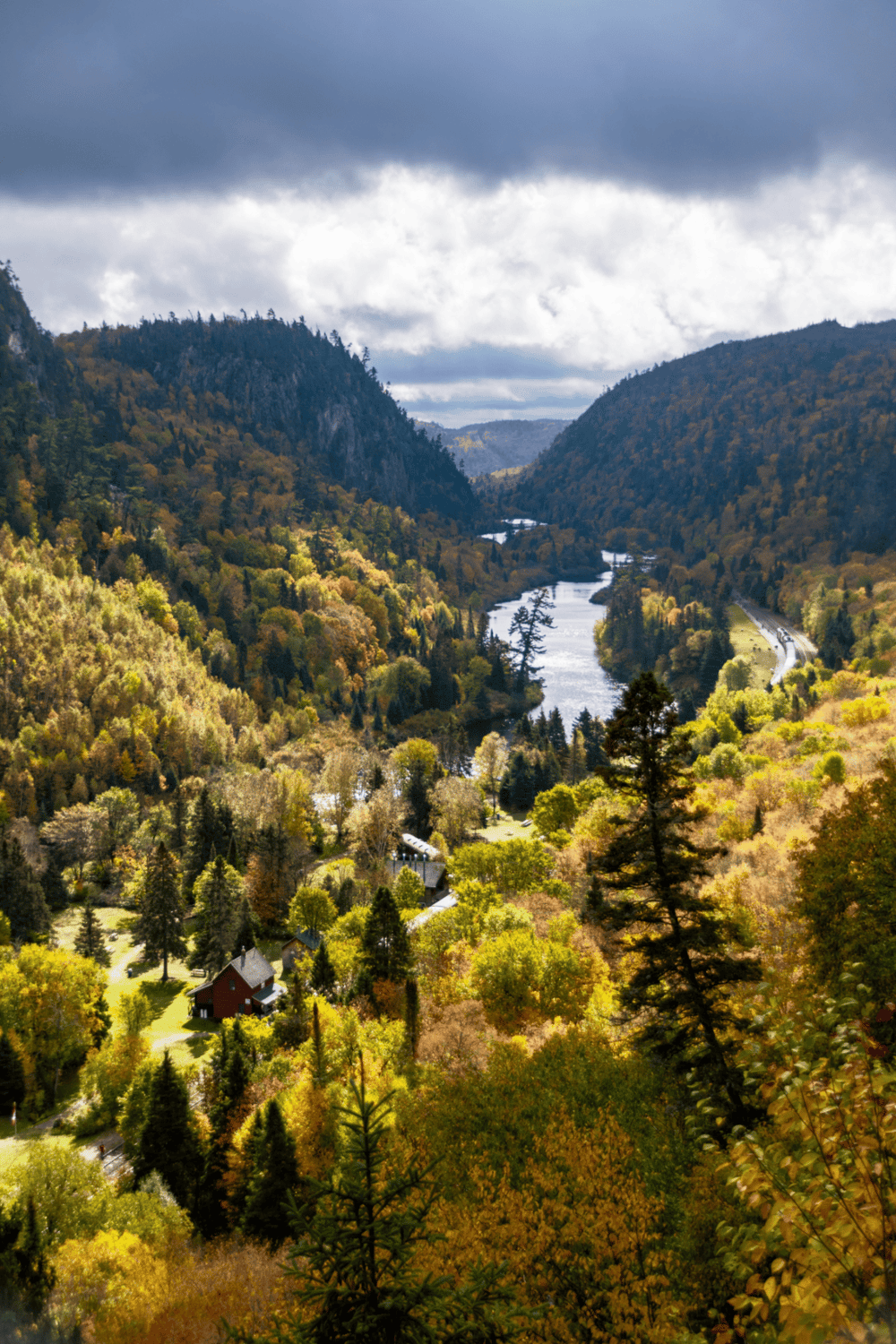 Majestic river winding through colorful autumn forested valley in scenic mountain landscape.