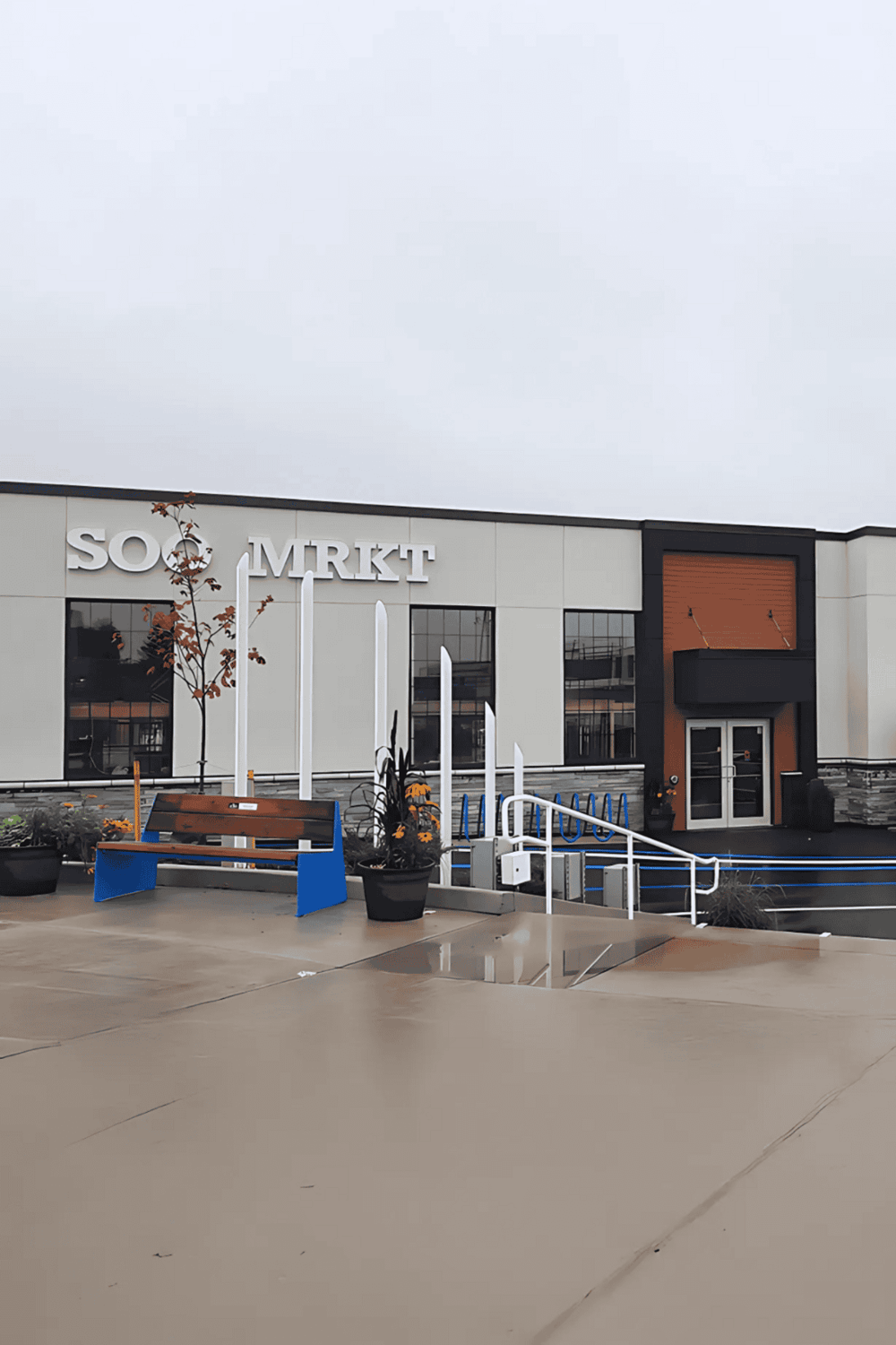 Modern retail store front at QuestForDirections shopping center, featuring accessible entrance and outdoor seating.