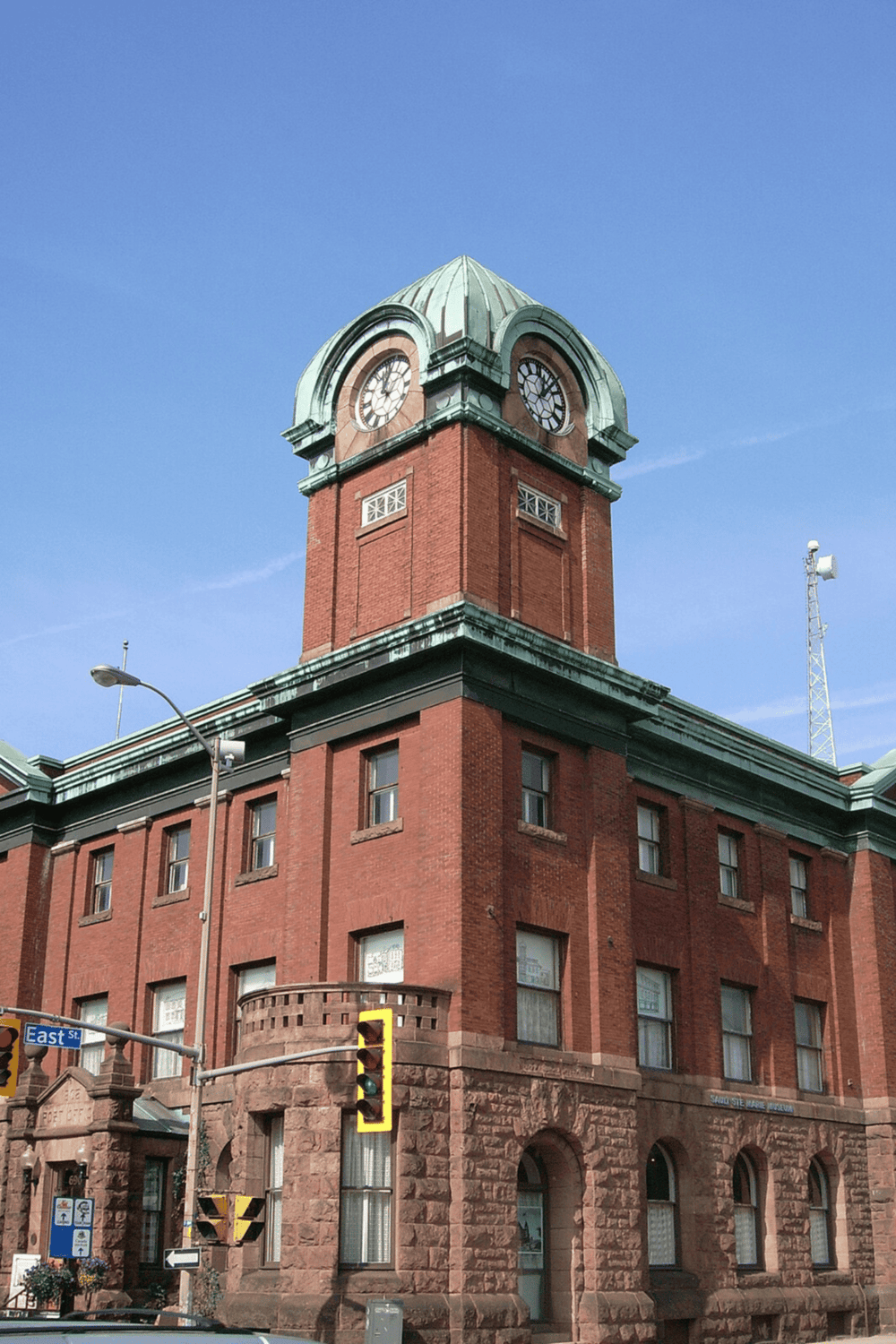 Clock tower building, historic architecture, downtown city, red brick, timepiece, urban landmark.