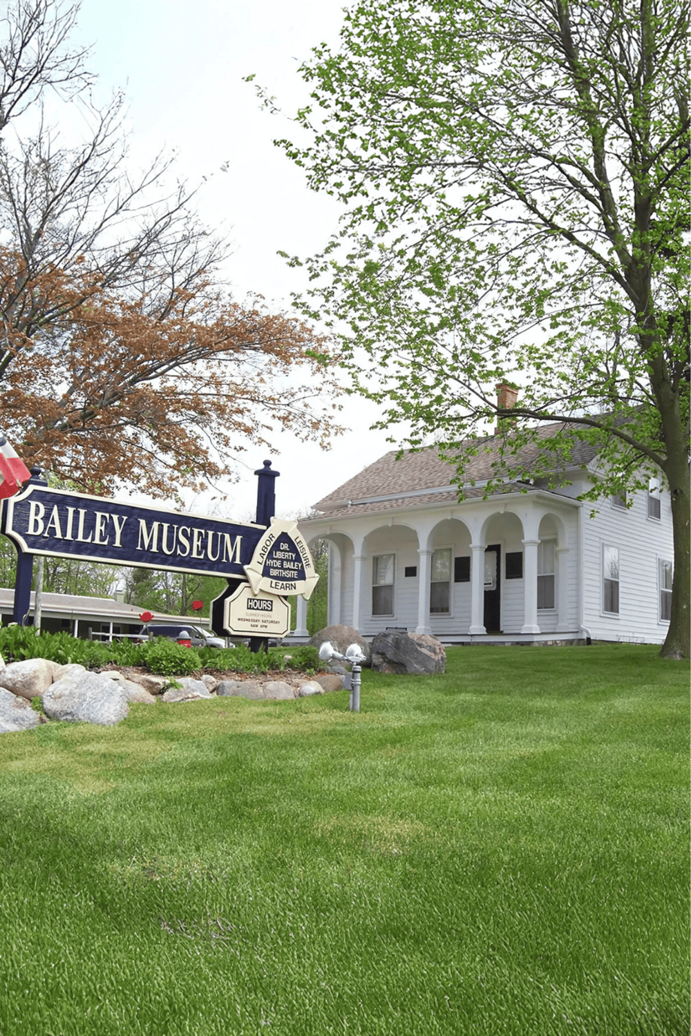Historic Bailey Museum with lush green lawn and white Victorian house, perfect for local history tours and community events.