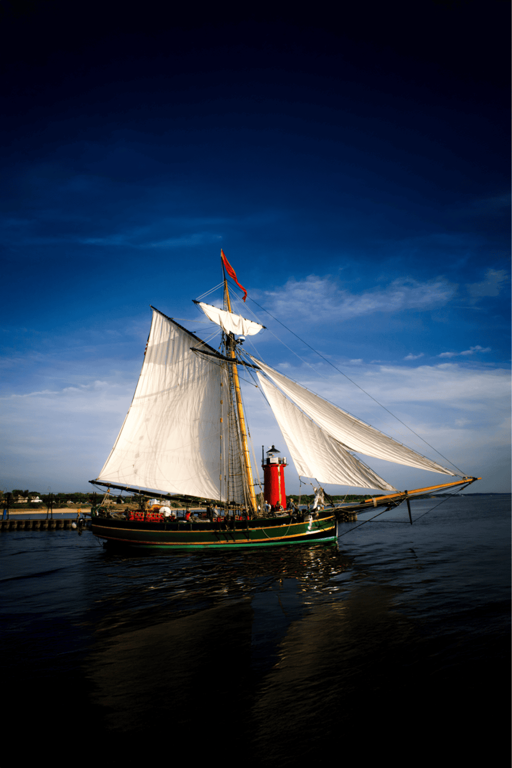1. Classic sailing ship with billowing white sails on calm water under a deep blue sky.