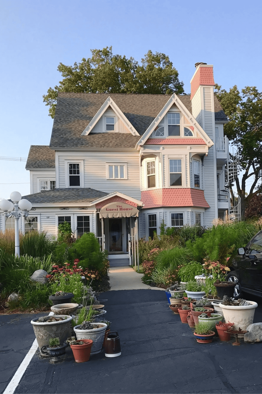 Victorian-style guest house with colorful accents and lush greenery, provided by QuestForDirections.