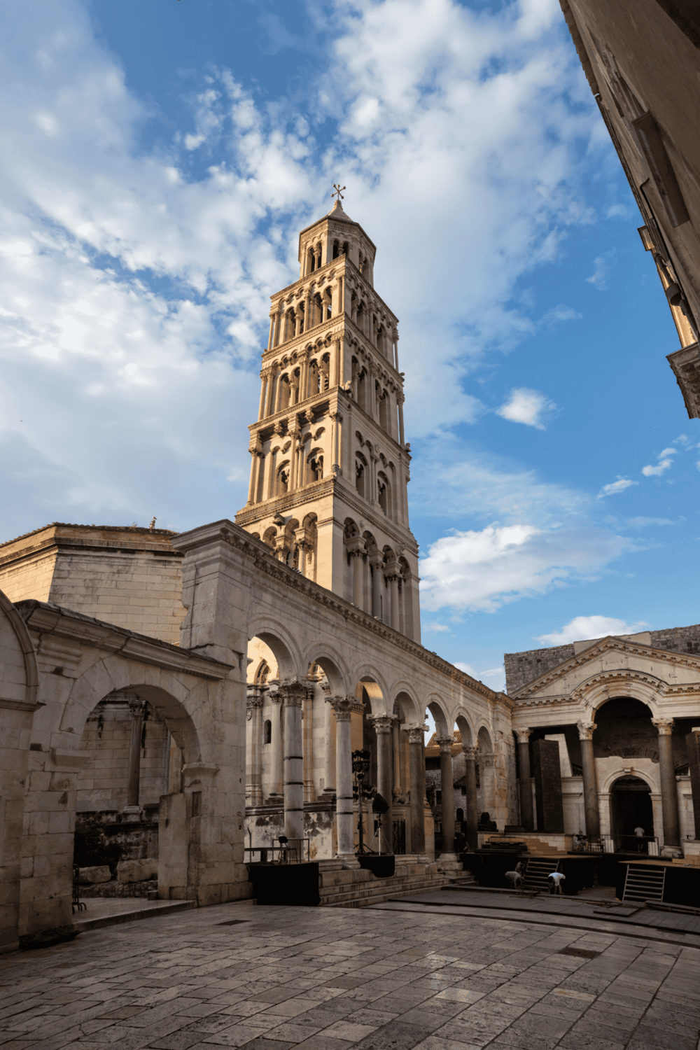 Ancient bell tower at the Cathedral of Saint Domnius in Split, Croatia, under a vibrant cloud-filled sky.