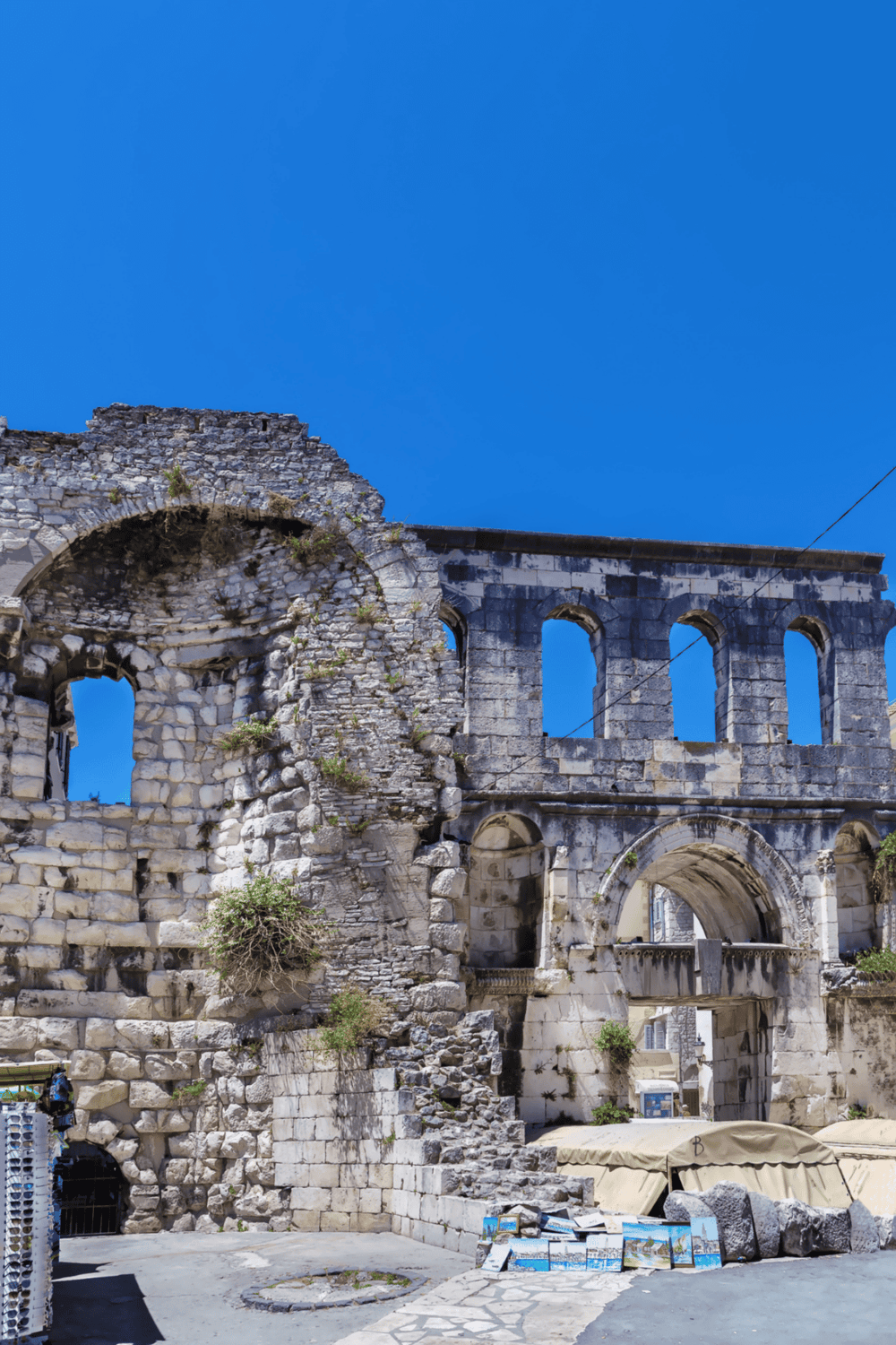 Ancient stone ruins with arches and blue sky, historical landmarks, travel destination, QuestForDirections.