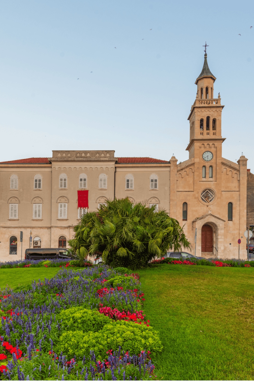 Colorful flower garden in front of historic church, scenic view for travel and directions.