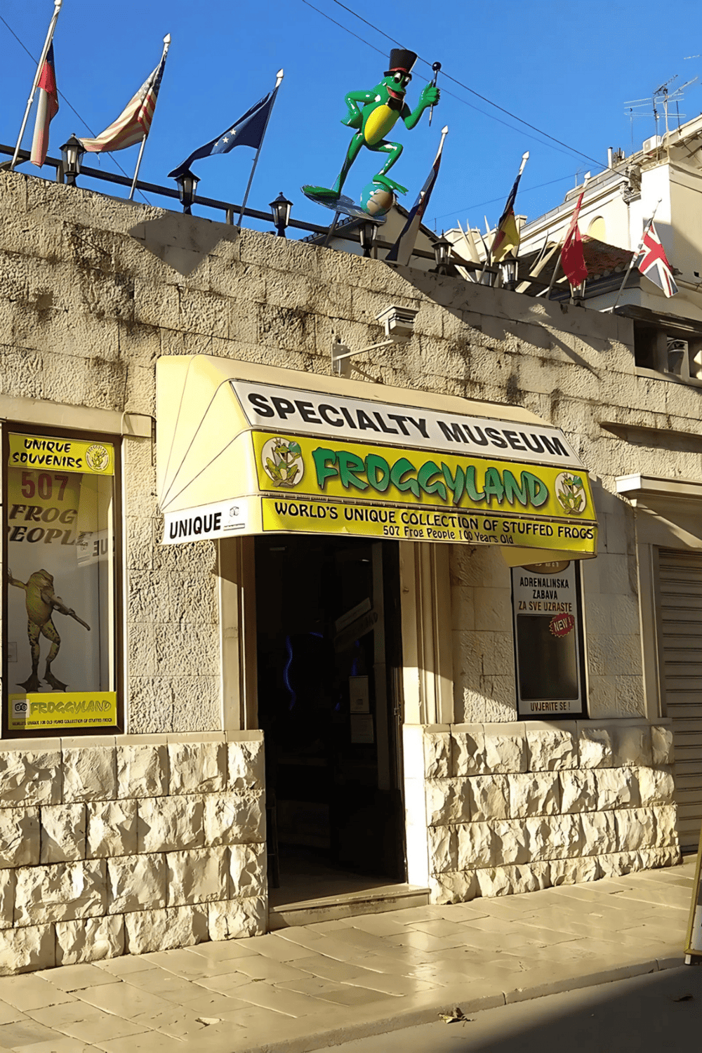 Colorful frog-themed museum entrance promoting unique stuffed frogs and tourist attractions.