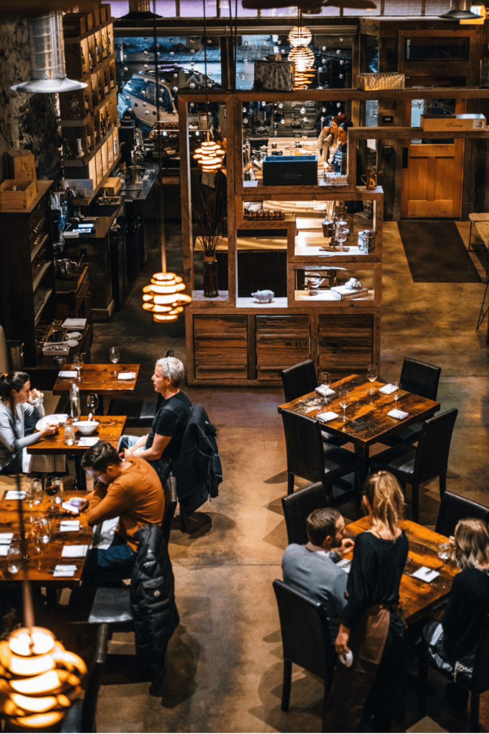 A cozy restaurant interior with warm lighting and customers dining in a rustic ambiance.