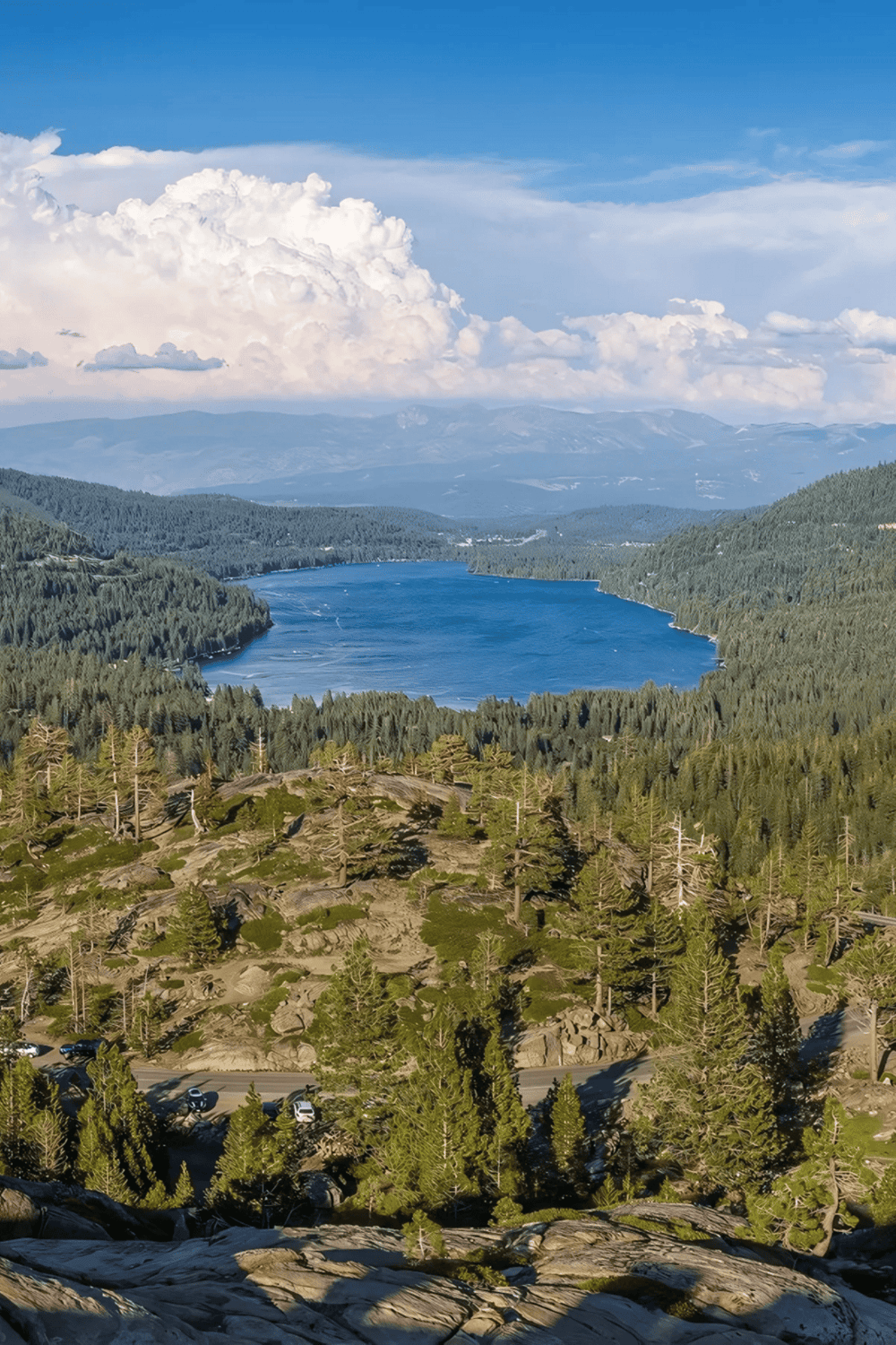 1. Spectacular mountain lake view with lush green forests and dramatic cloudscape.