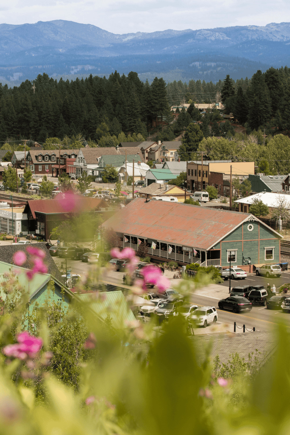 Charming small town with mountain backdrop and lush greenery, ideal for travel and outdoor adventures.