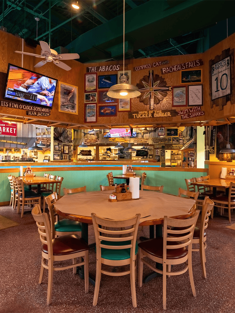 Cozy restaurant interior with wooden decor, wall art, and colorful seating, perfect for family dining and casual gatherings.