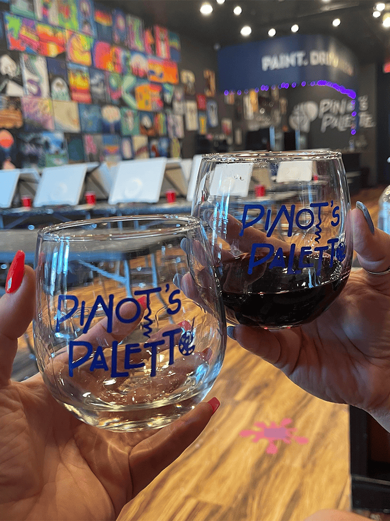 Enjoying wine at Pinot’s Palette art studio with friends in a colorful, artsy environment.