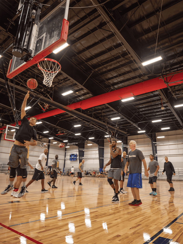 High school basketball game in indoor gym, players shooting and defending efficiently.