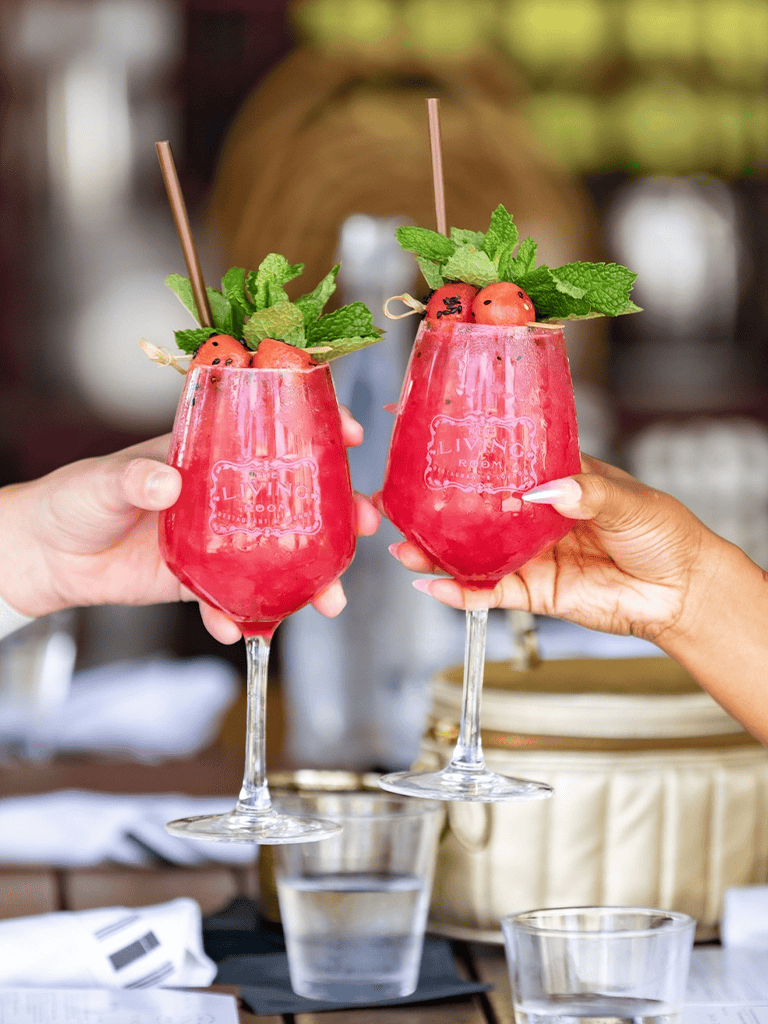 Bright pink strawberry cocktails garnished with mint and strawberries, served in elegant glasses.