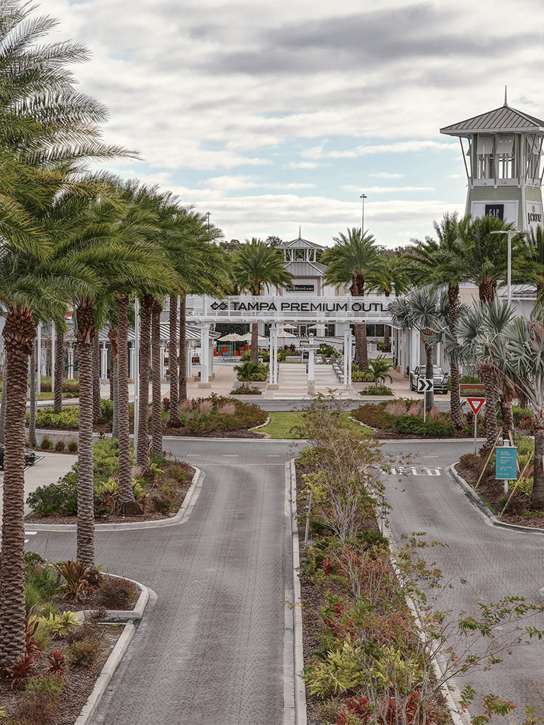 Palm trees and Tampa Premium Outlets entrance in Florida.