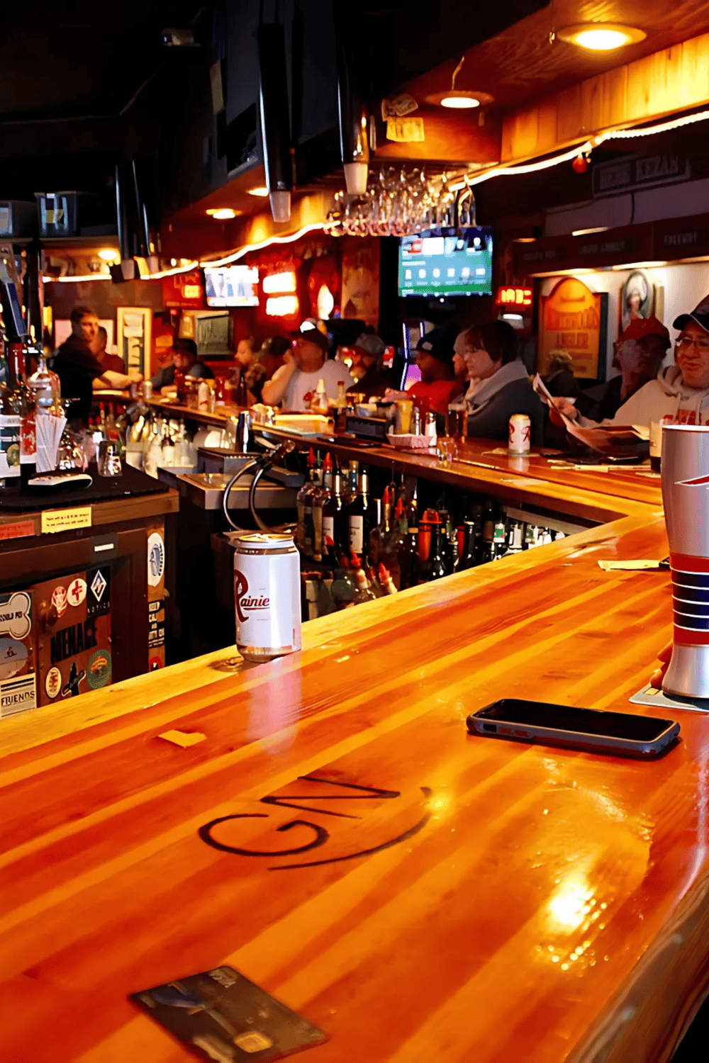 Cozy bar interior with active patrons at QuestForDirections, lively sports screens, and a warm ambiance.