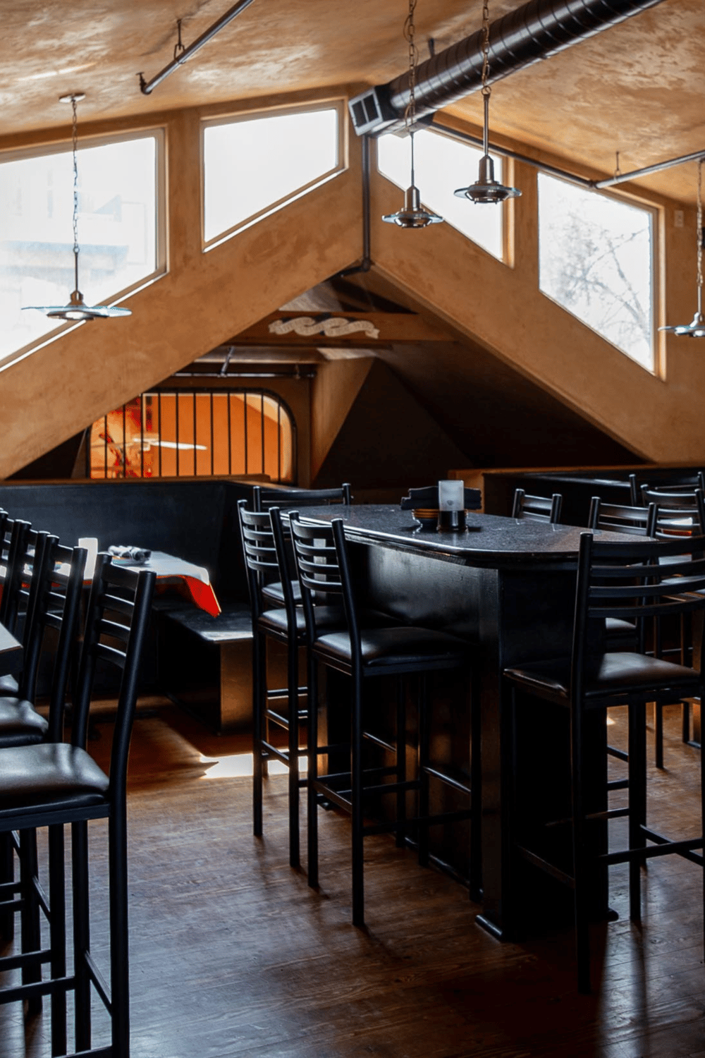 Cozy restaurant interior with modern design, wooden accents, and natural light, ideal for dining and socializing.