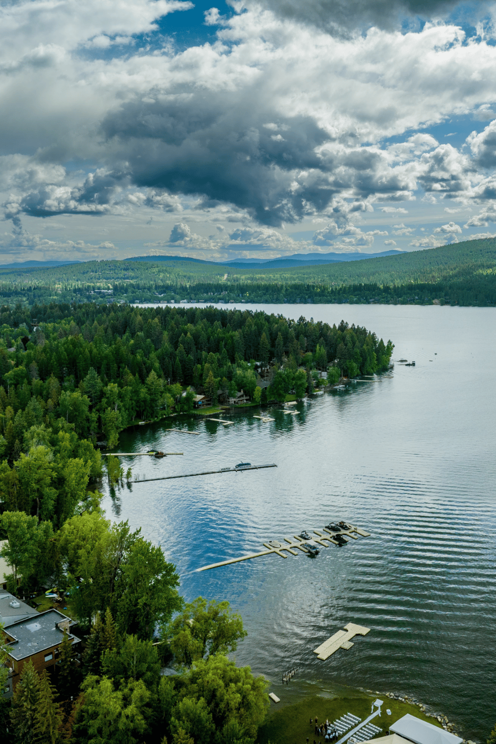 Serene lakeside view with lush green trees, boats, and mountain backdrop in Oregon.