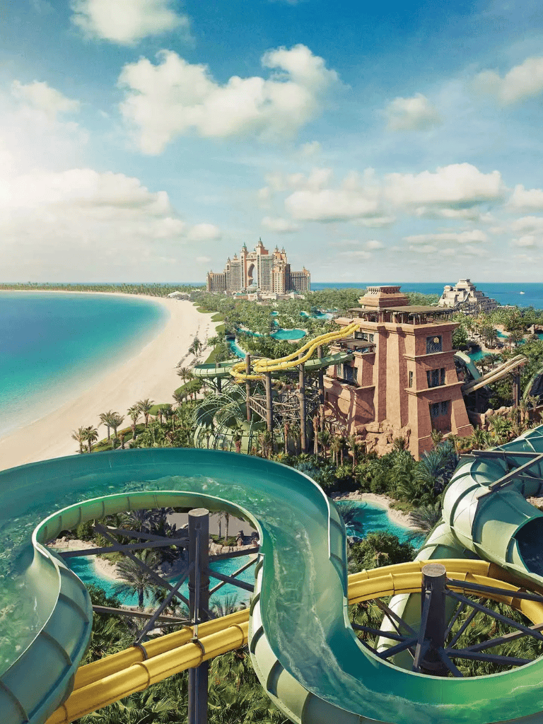 Thrilling water slides at Atlantis Paradise Island, Bahamas, with ocean and resort views in the background.