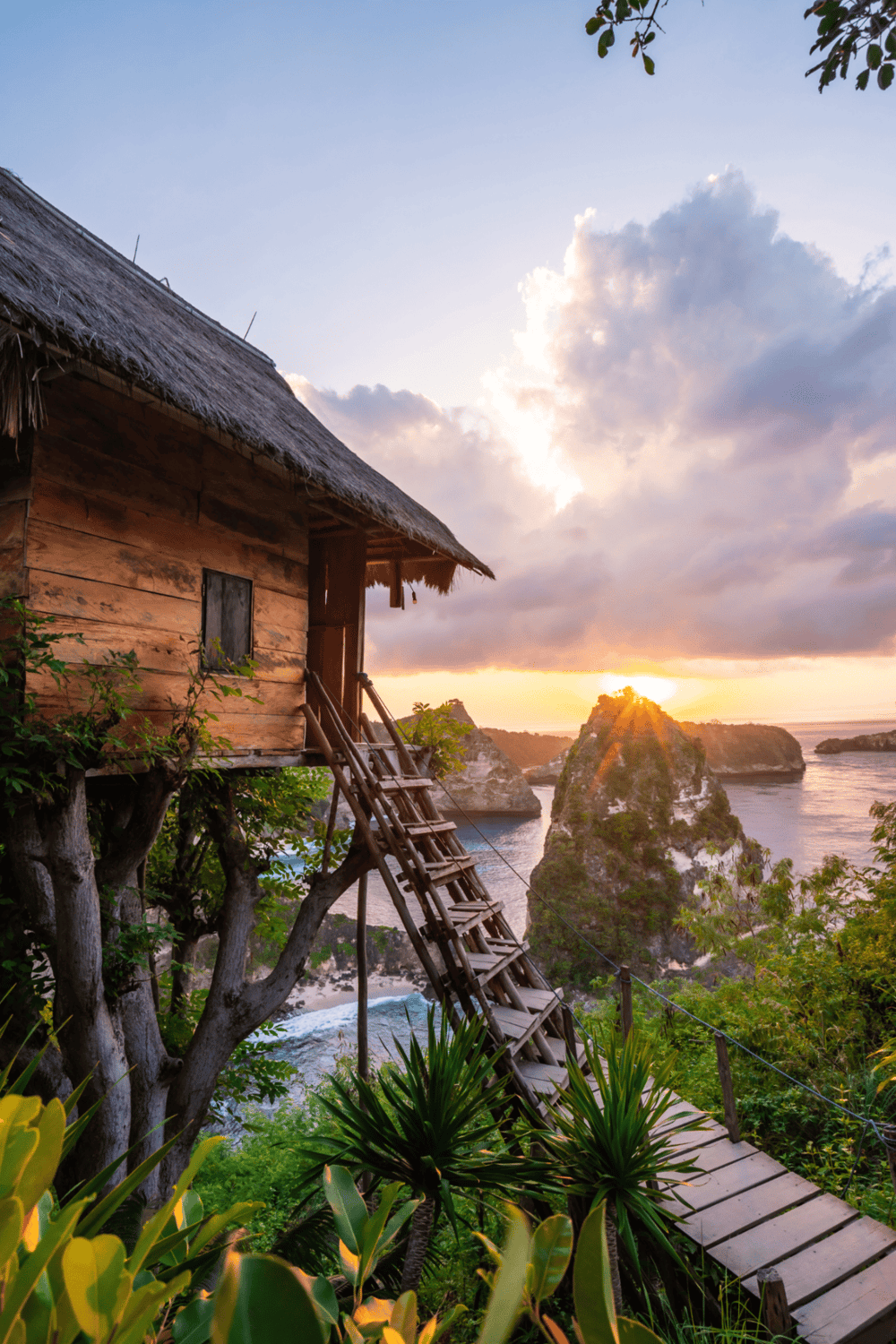 Treehouse overlooking coastal cliffs at sunset, tropical scenery, adventure travel destination, scenic ocean view.