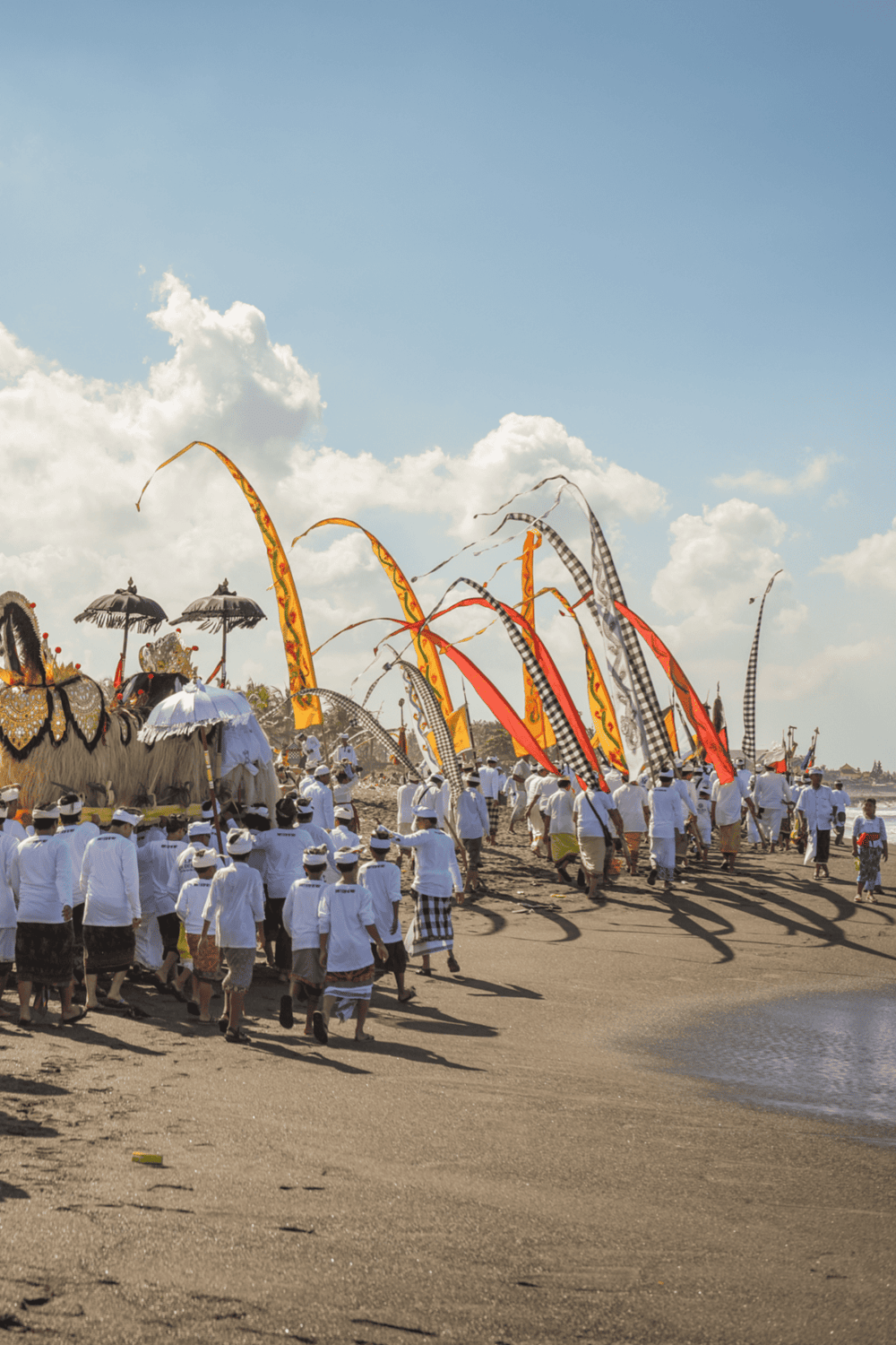 Colorful traditional Balinese Ondel-ondel parade along the beach in Bali during cultural festival.