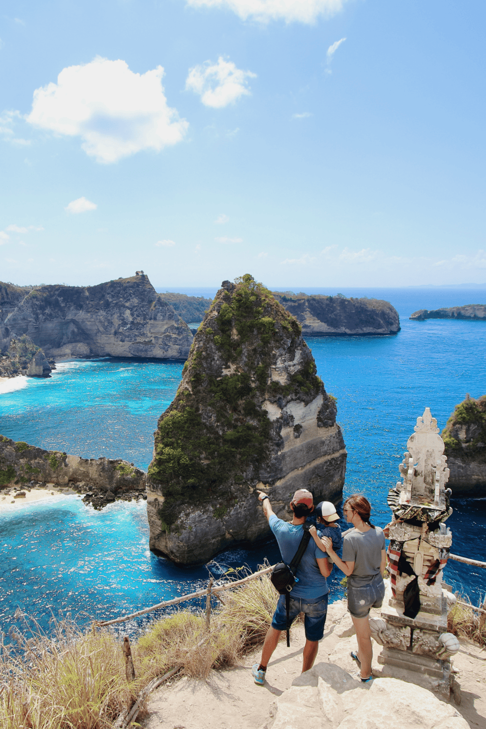 Vibrant coastal scenery with travelers enjoying a scenic viewpoint in Bali, Indonesia at Kelingking Beach.