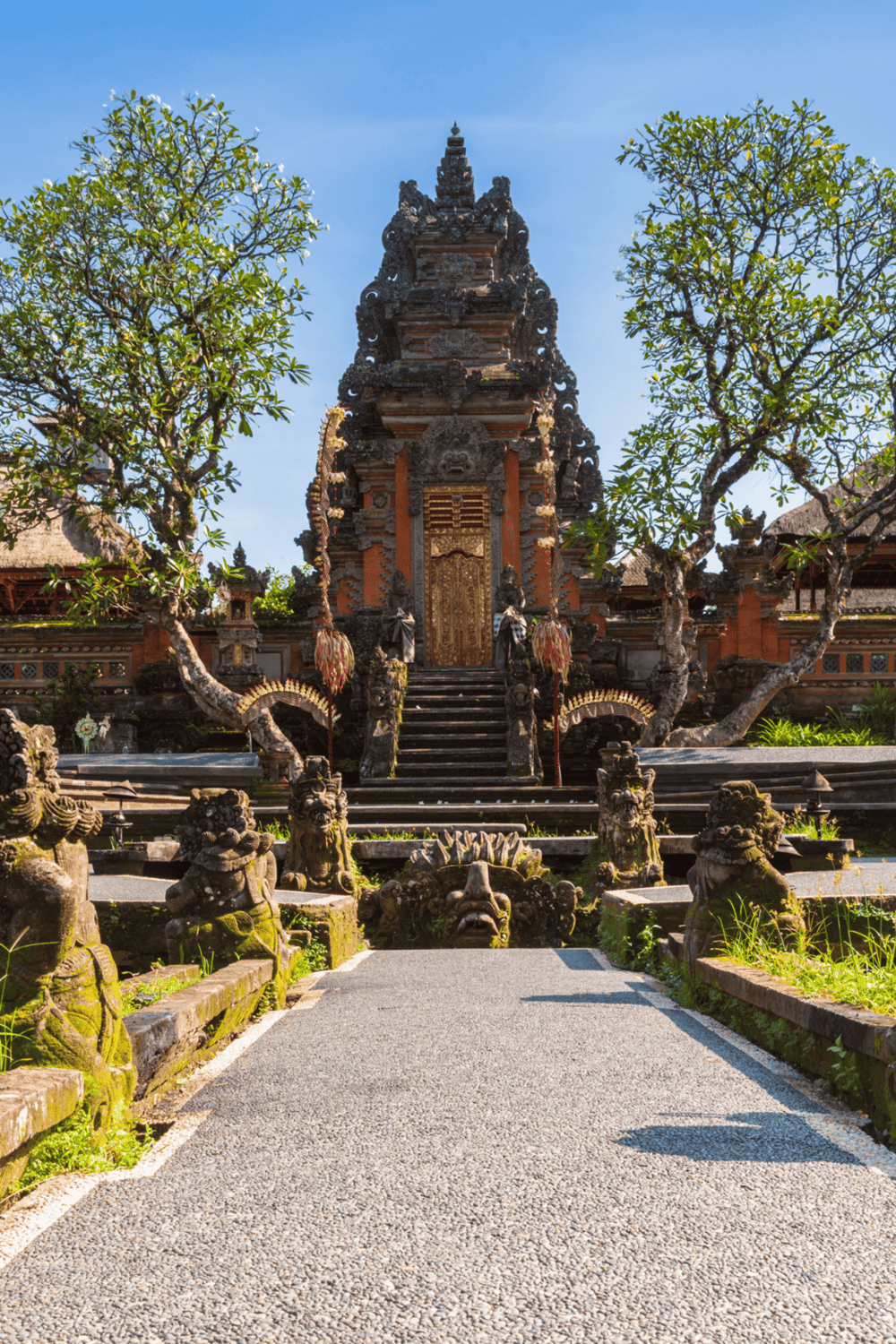1. Traditional Balinese temple with intricate stone carvings and lush greenery.