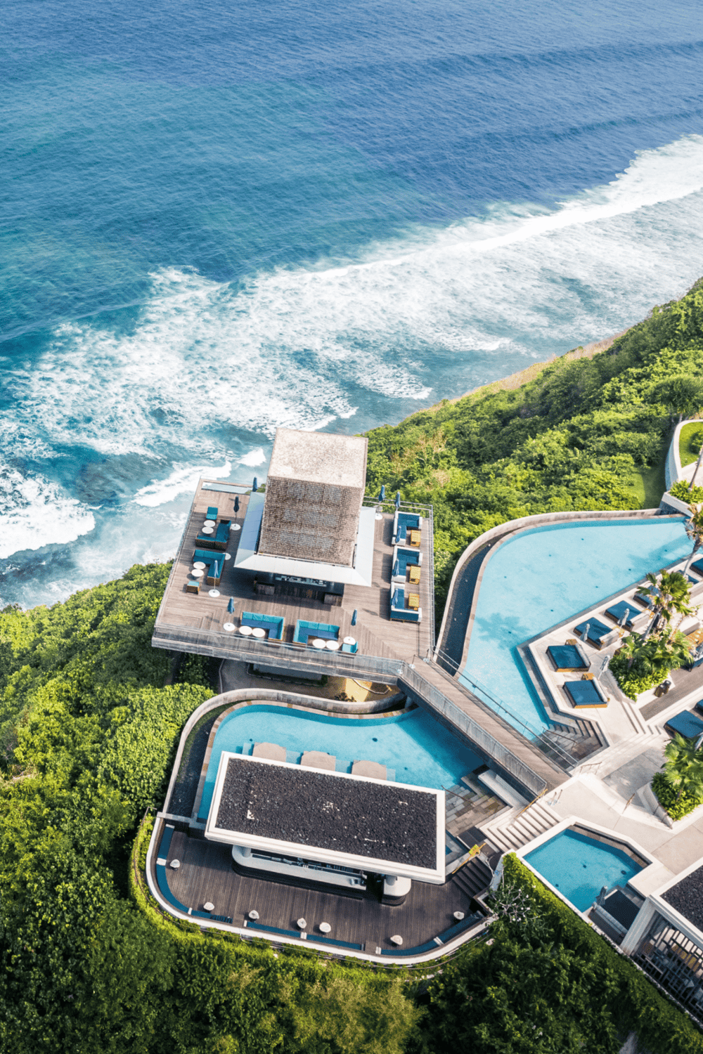 Overwater resort with infinity pools and ocean view, luxury vacation destination, tropical seaside retreat.