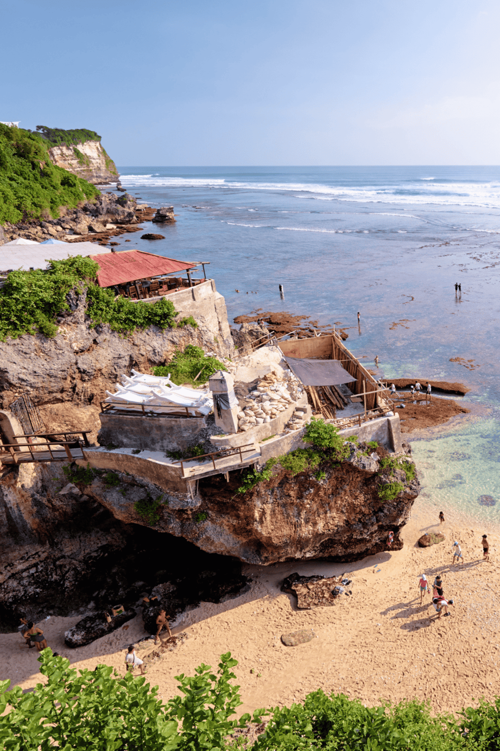 Breathtaking coastal cliffside restaurant with ocean views, ocean waves, and sandy beach scenery for travel inspiration.