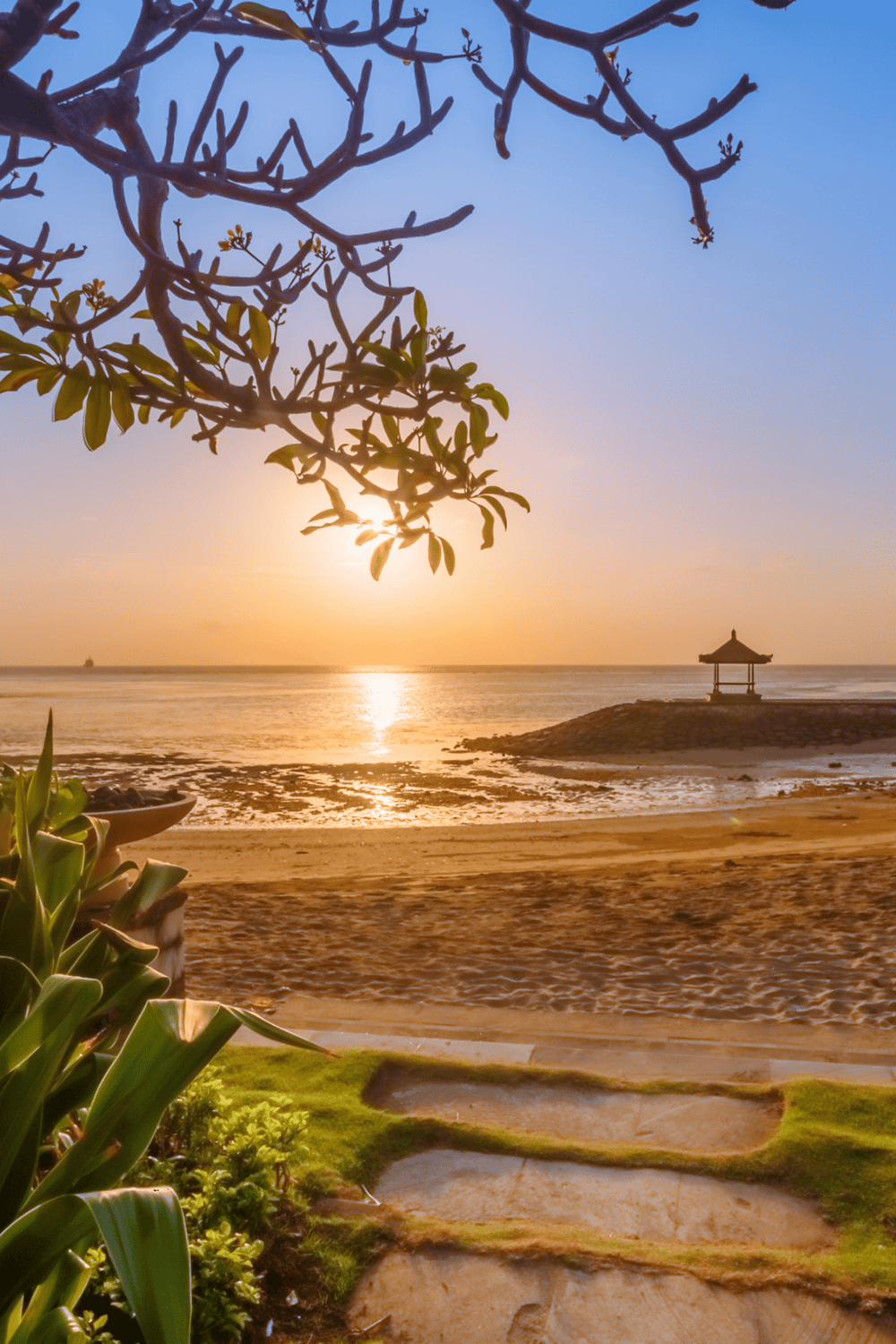 Tranquil beach sunset scene with traditional gazebo, perfect for vacation planning and travel guides.