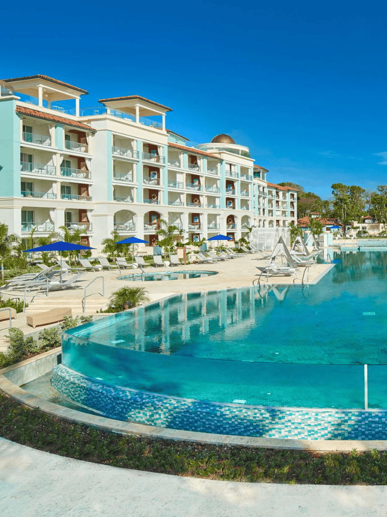 Luxurious beachfront resort with pools and ocean views, perfect for vacations and relaxation.
