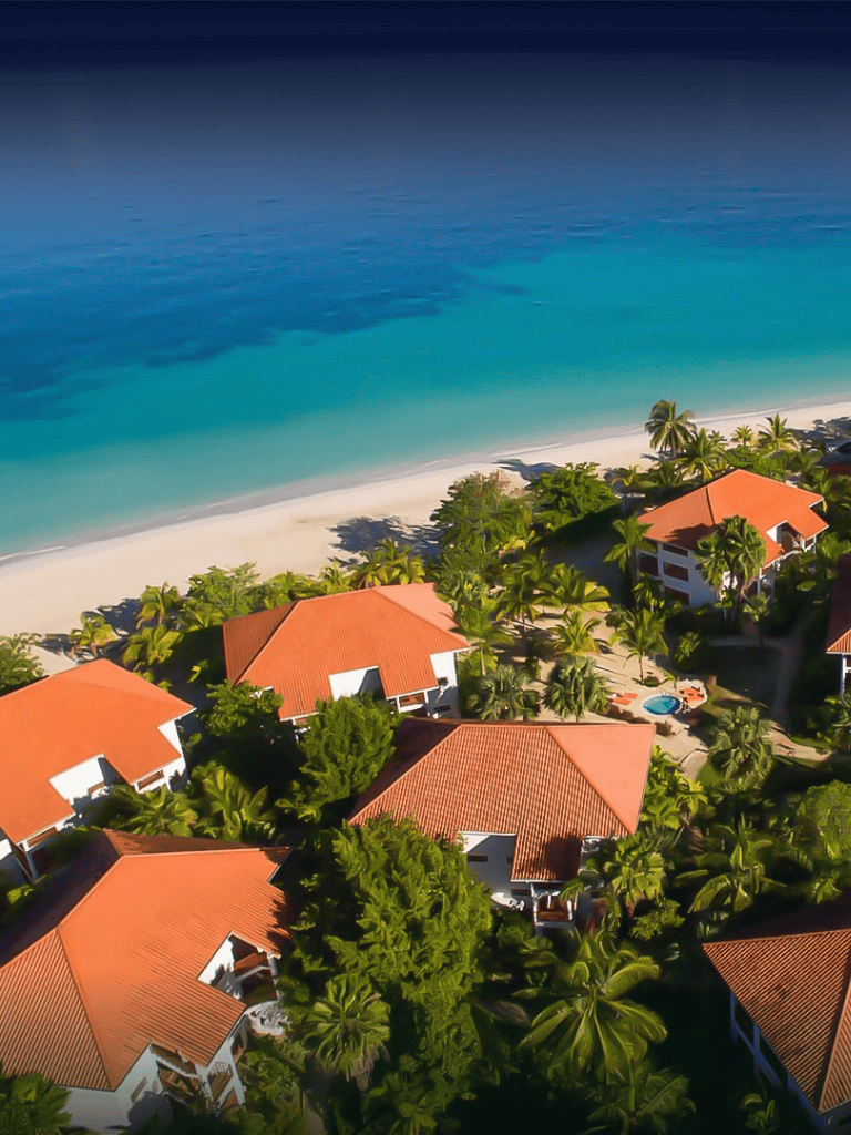 Luxurious beachside resort with tropical greenery and ocean views.