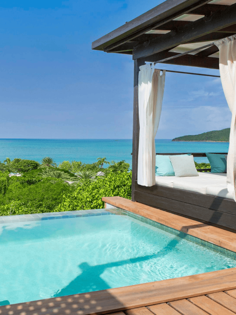 Luxurious oceanview resort with private pool and cabana overlooking lush greenery and turquoise sea.