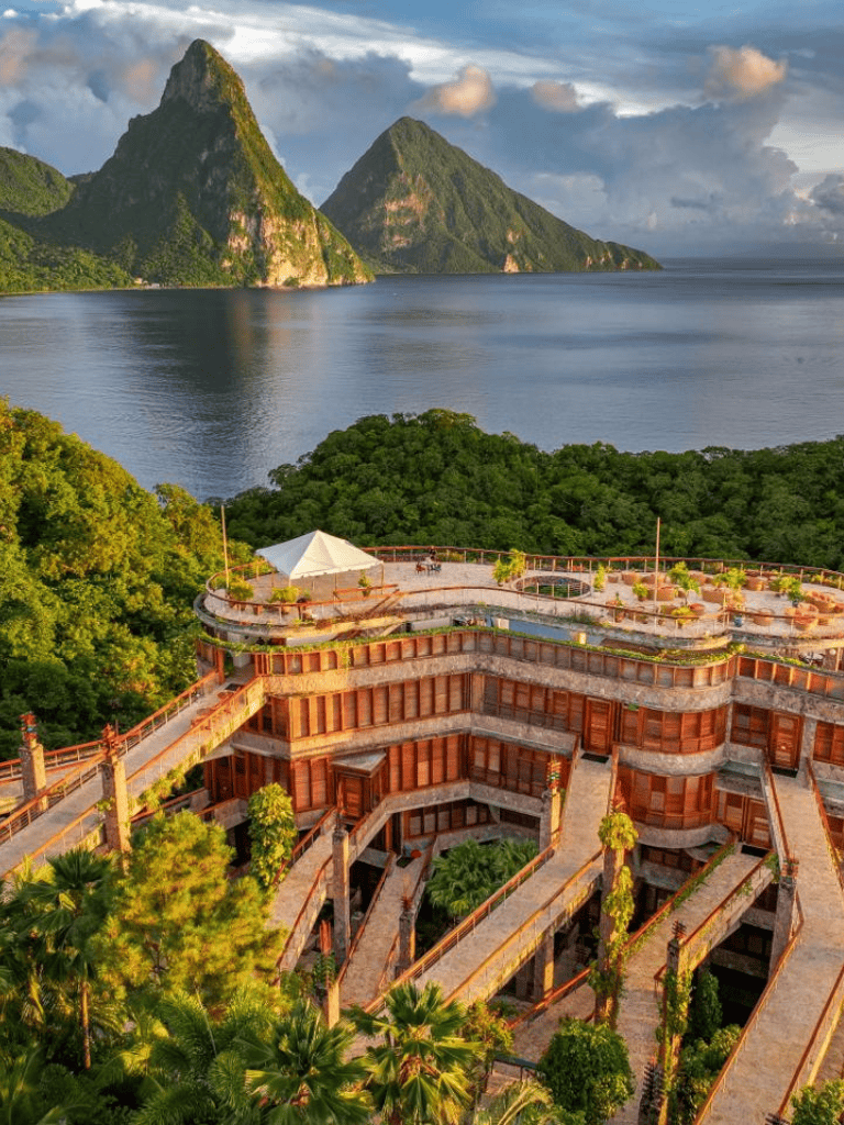 Breathtaking view of mountains and lake with a luxurious resort in lush greenery.