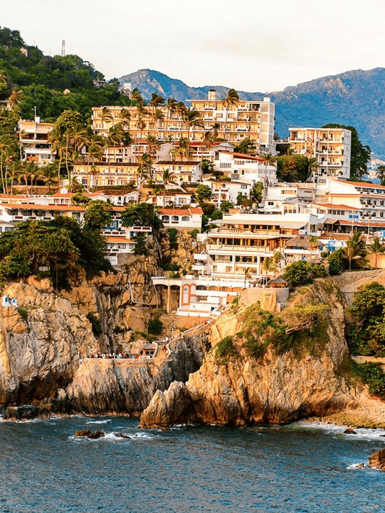 Clifftop luxury condos in Acapulco with ocean views and tropical landscape.