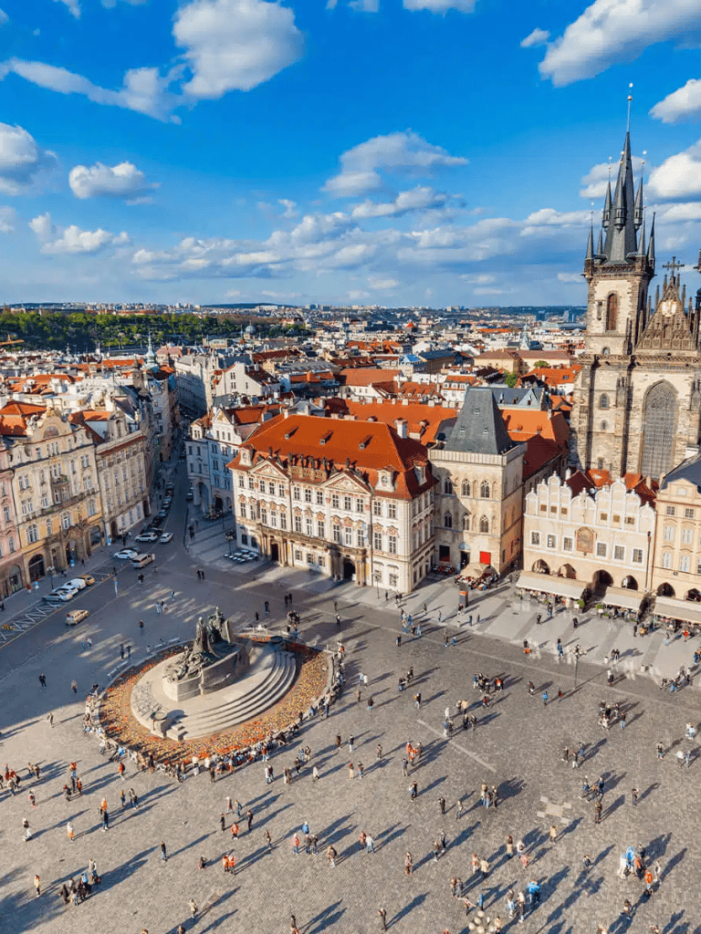 Historic Prague Old Town Square with colorful buildings and clock tower at sunset.