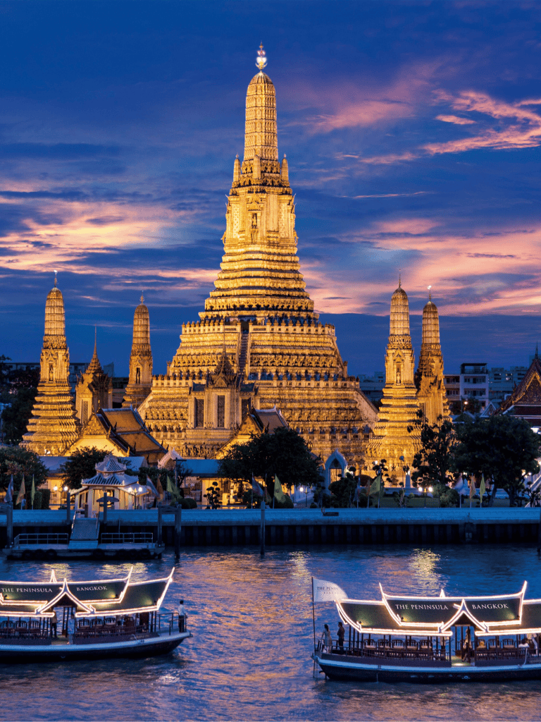Ancient Thai temple at sunset along Chao Phraya River in Bangkok, Thailand.