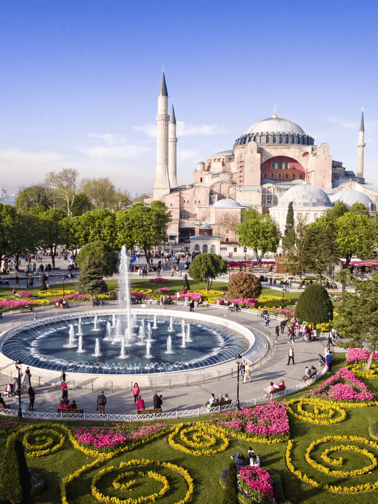 Magnificent Hagia Sophia mosque in Istanbul with lush gardens and colorful flowerbeds.