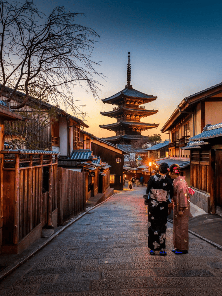 Ancient Japanese street with traditional architecture and pagoda at sunset, cultural exploration in Kyoto.