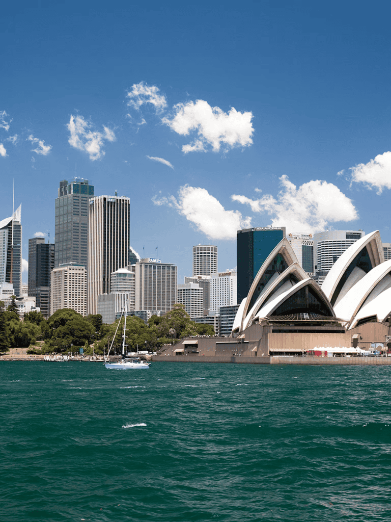 Stunning Sydney Opera House and city skyline with water view on a sunny day.
