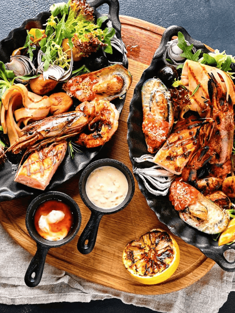 Succulent grilled seafood platter with lemon and sauces, perfect for seafood lovers and dinner parties.