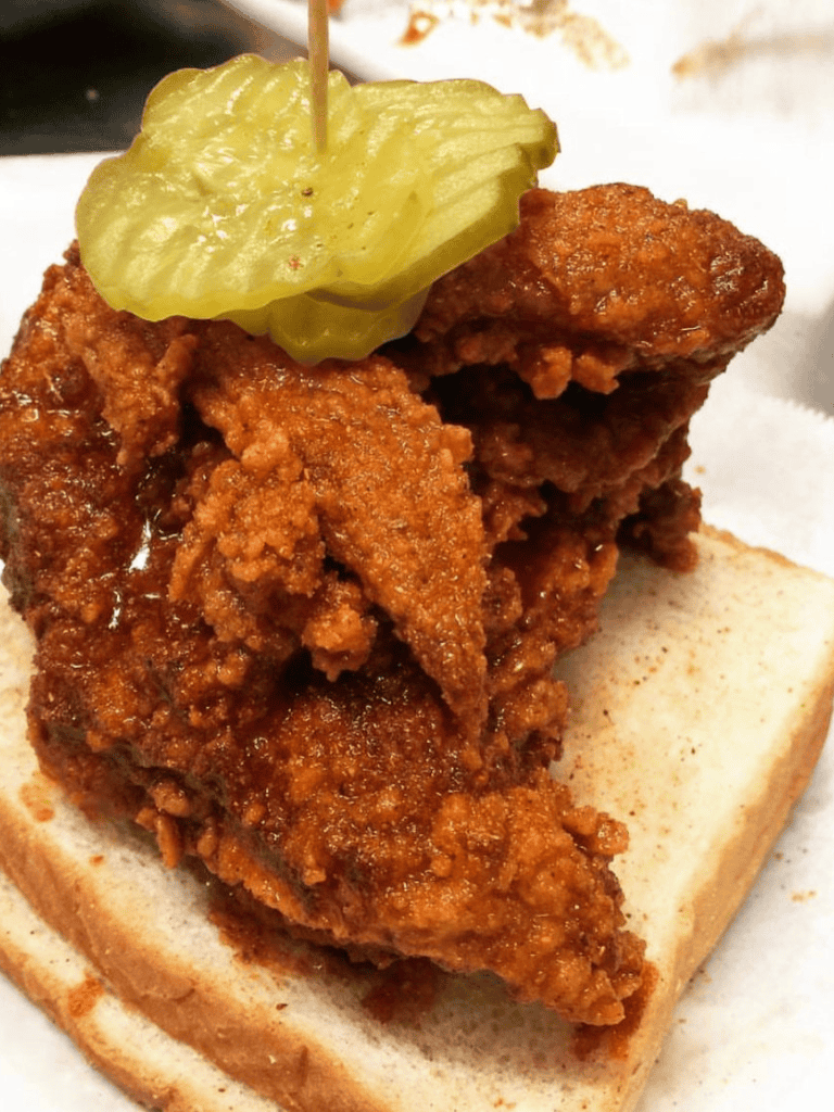 Crispy fried chicken with pickles on a sandwich bun, classic comfort food.