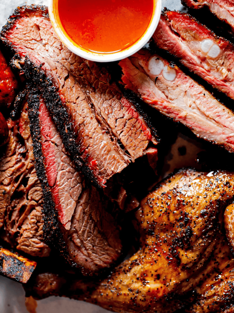 Juicy grilled steak with barbecue sauce and seasoned chicken drumstick, delicious meat platter.