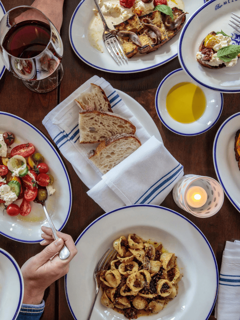 Delicious Italian pasta, fresh bread, and wine served at a cozy restaurant.