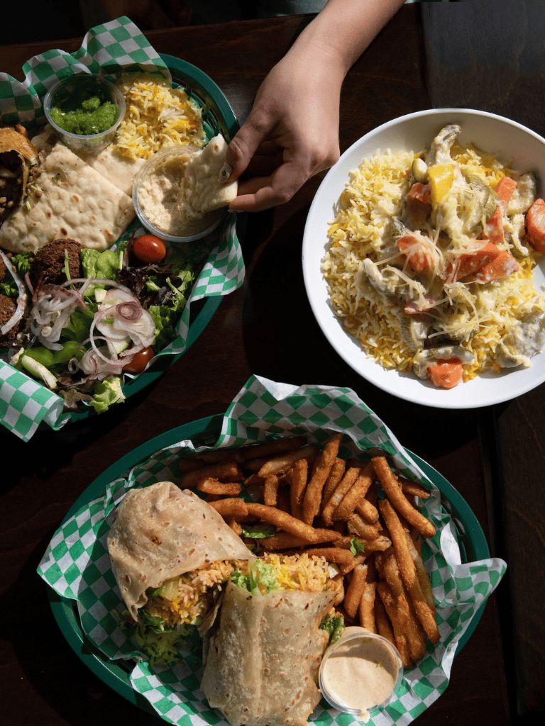 Vegetarian Mexican platter with burrito, rice, fries, fresh salad, and dipping sauces, authentic Mexican cuisine.