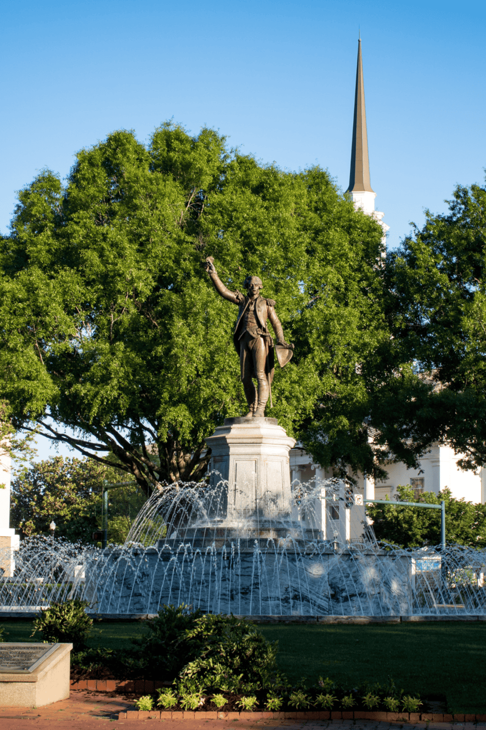 Historic downtown Spartanburg fountain with a statue and church spire in the background.