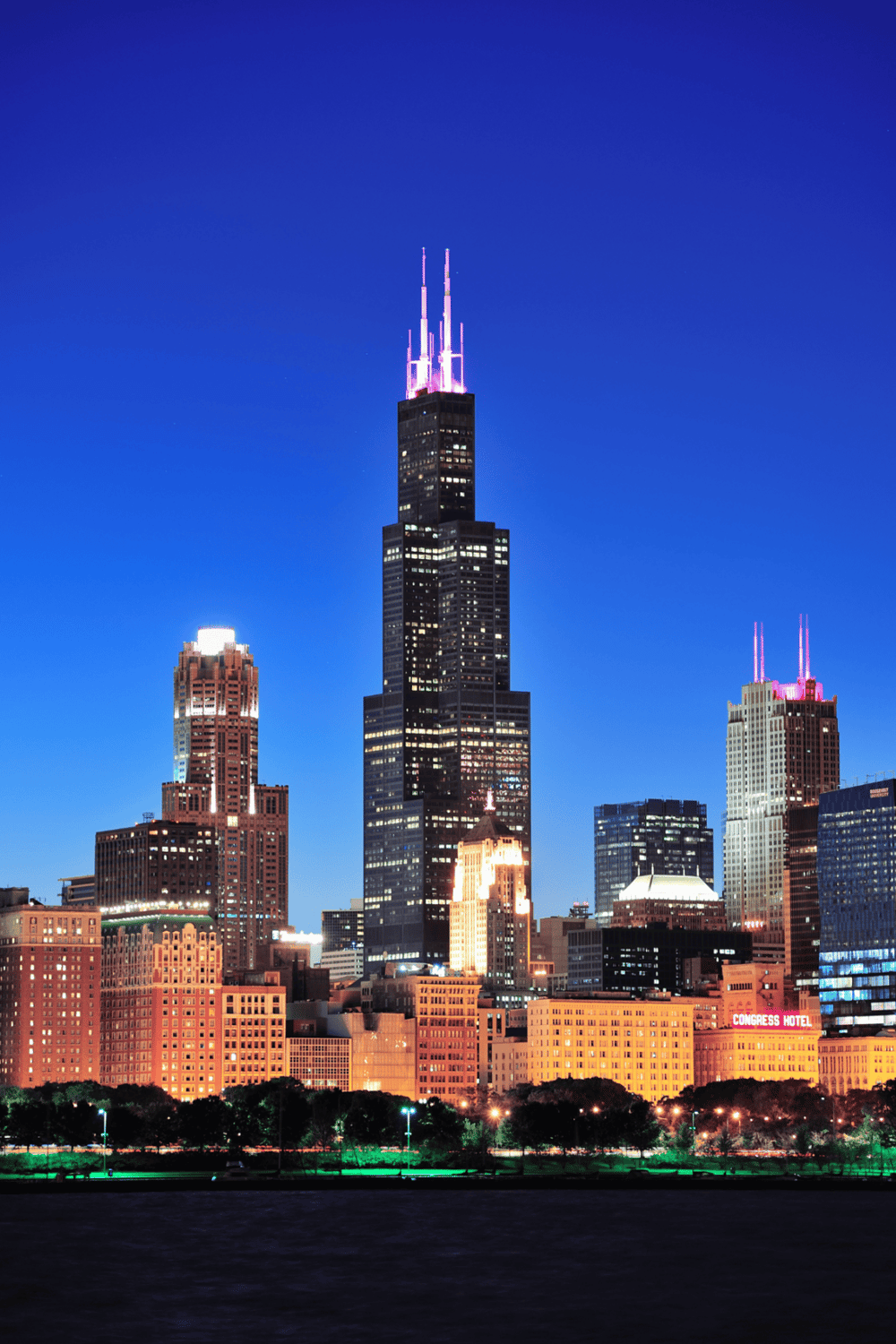 Skyscraper in Chicago illuminated at night with QuestForDirections branding in the URL.