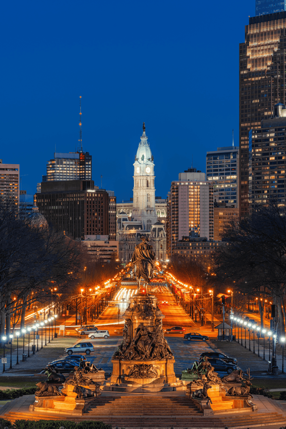 Bright Philadelphia City Hall and historic architecture at dusk, featuring illuminated streets and skyscrapers.