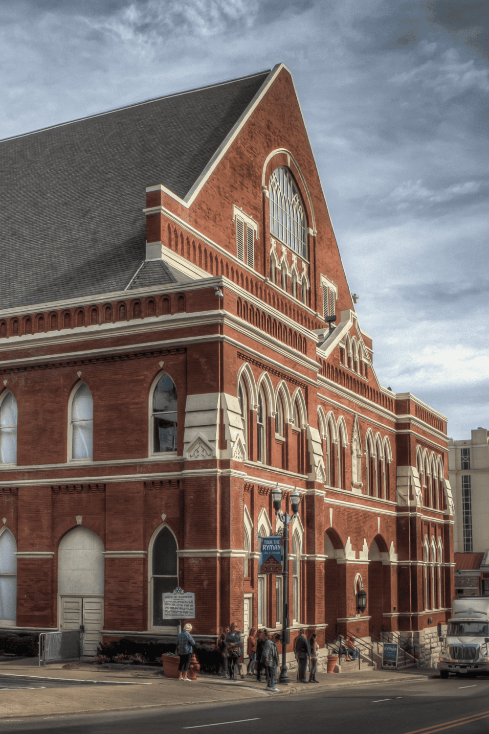 Victorian-style historic building in downtown with Gothic arches and large stained glass window.