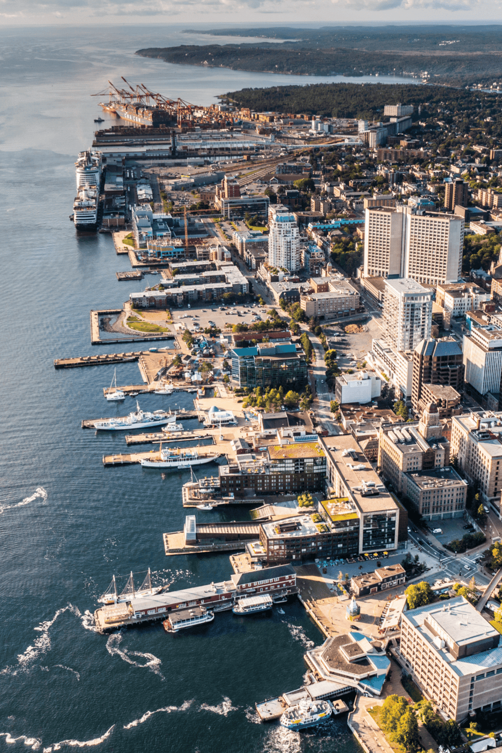 1. Aerial view of waterfront cityscape with docks, high-rise buildings, and ships in the harbor.